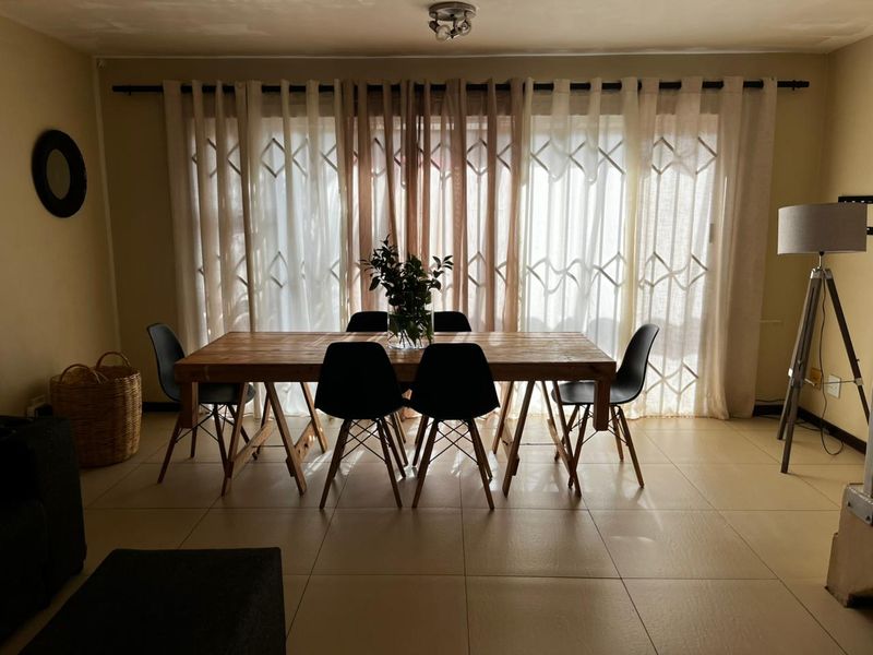 A dining area featuring tiled flooring and large sliding glass doors that provide ample natural light.