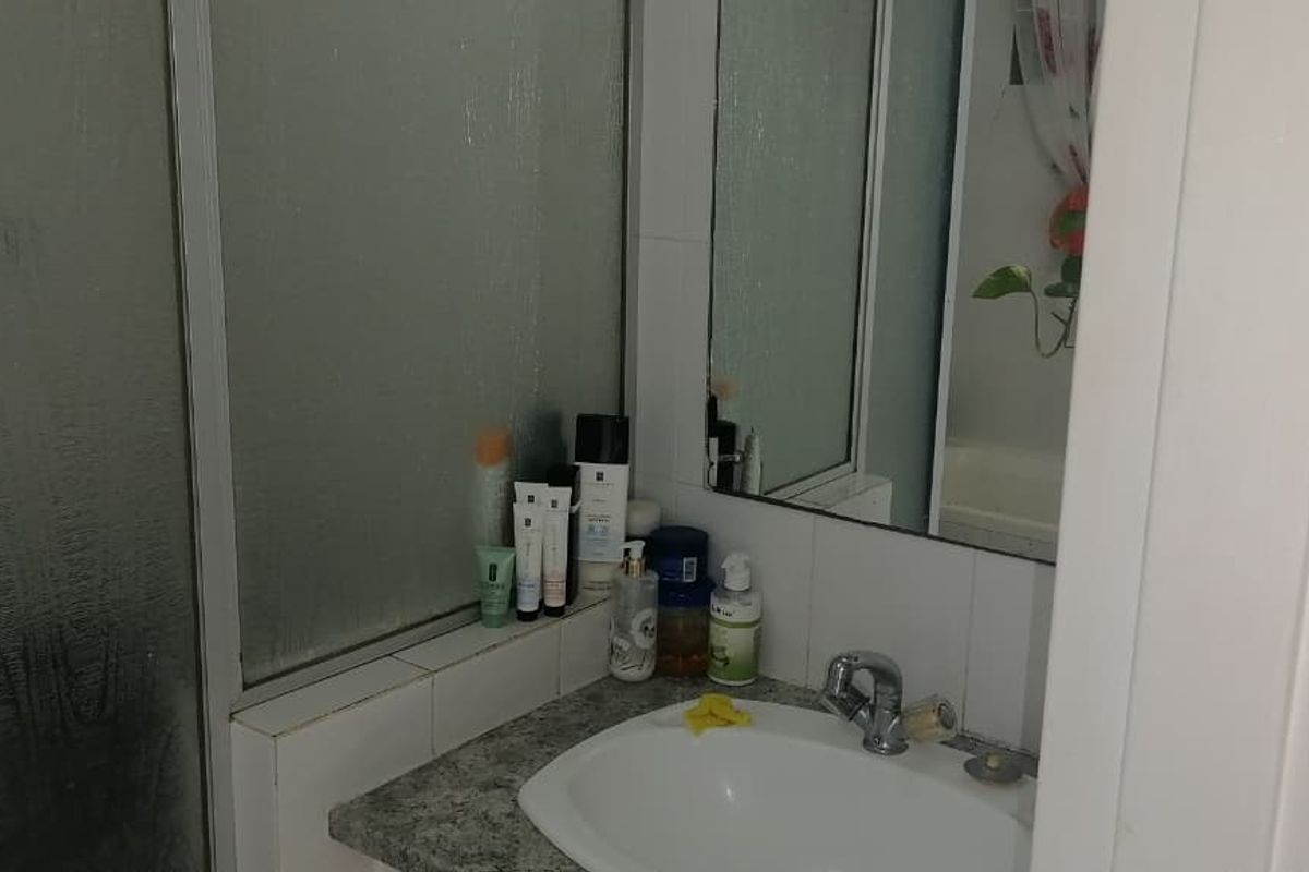 A functional bathroom featuring a vanity with a basin, a mirror, and a shower enclosure with a sliding door.