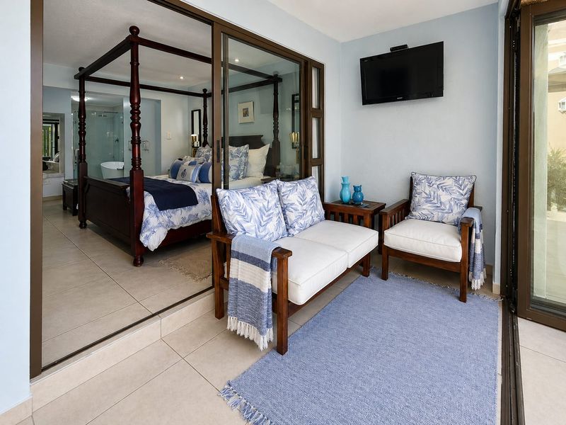 A covered patio area featuring tiled flooring and large sliding glass doors that provide a seamless transition into the adjacent bedroom suite.