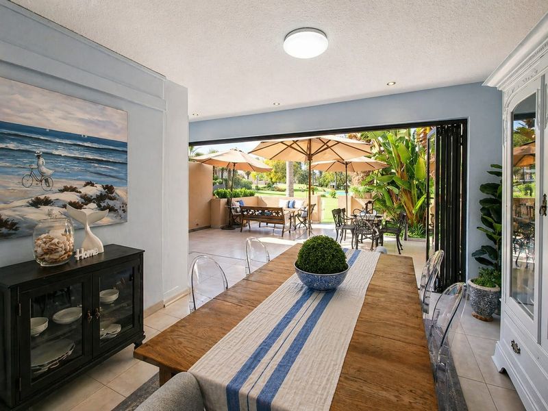 Open plan dining area featuring large bi-fold doors that open onto a covered patio, creating a seamless indoor-outdoor flow.