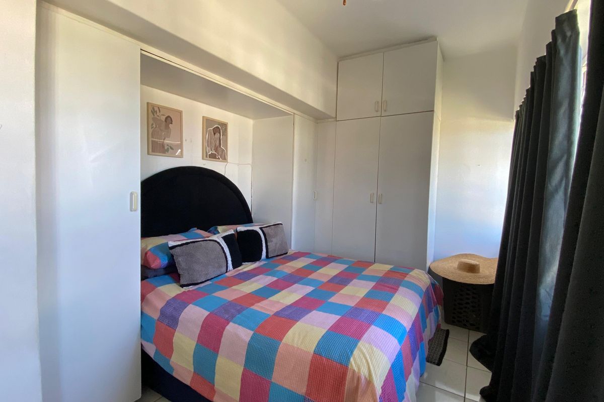 A bedroom featuring built-in cupboards and tiled flooring, offering functional storage space.