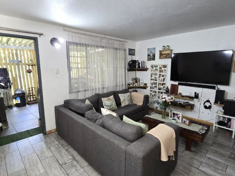 A comfortable living room featuring tiled flooring and direct access to an outdoor patio area through a sliding door.