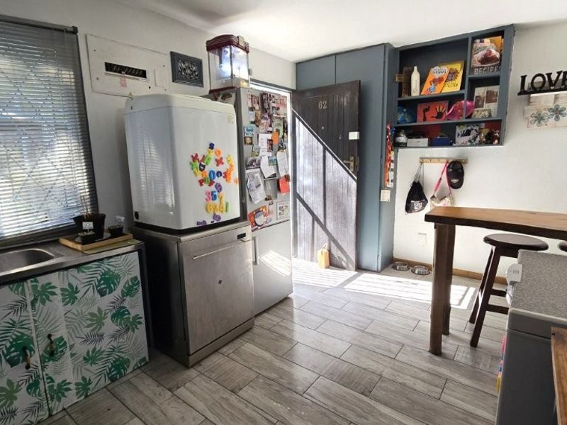 A functional kitchen area featuring tiled flooring, built-in cabinetry, and integrated shelving, providing a practical layout for daily use.