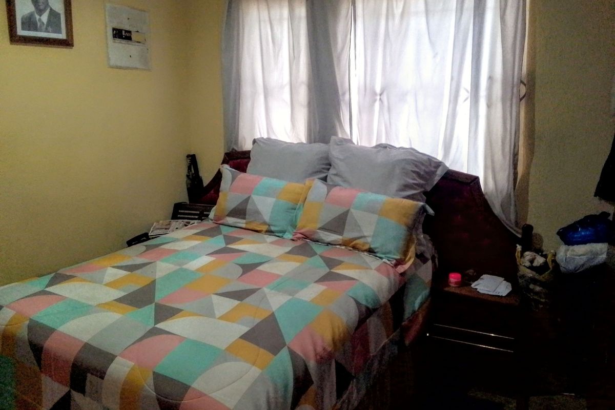A bedroom featuring a window with curtains, providing natural light to the space.