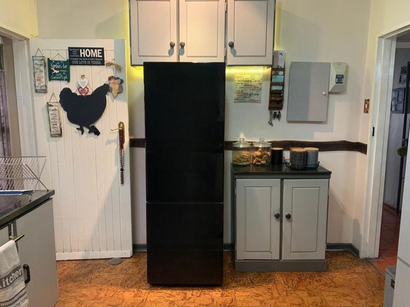 A functional kitchen area featuring built-in cabinetry, under-cabinet lighting, and durable cork flooring, providing a practical space for food preparation and storage.