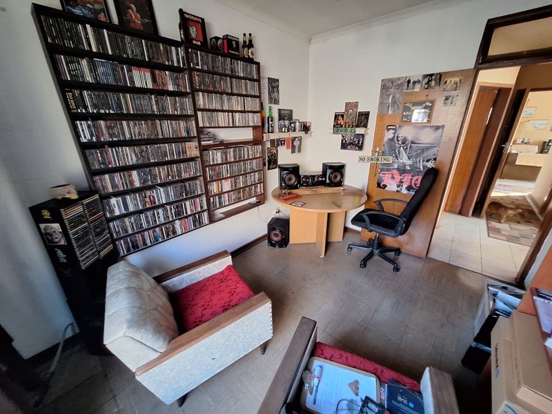 A living area featuring extensive built-in wall shelving, providing ample storage space for media collections.