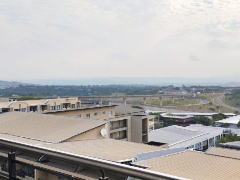 Elevated panoramic view overlooking the surrounding urban landscape, highway infrastructure, and neighboring residential apartment complexes.