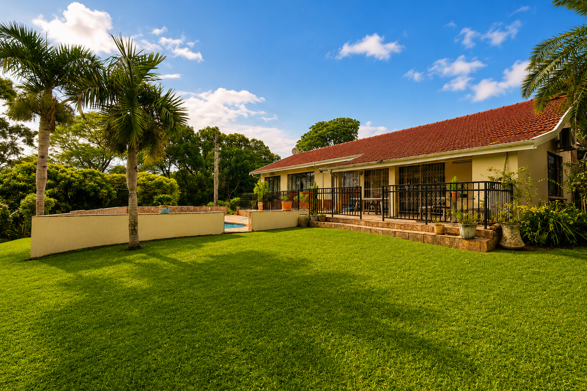 Rear view of the property featuring a spacious lawn, a covered patio area, and a swimming pool set within a well-maintained garden.