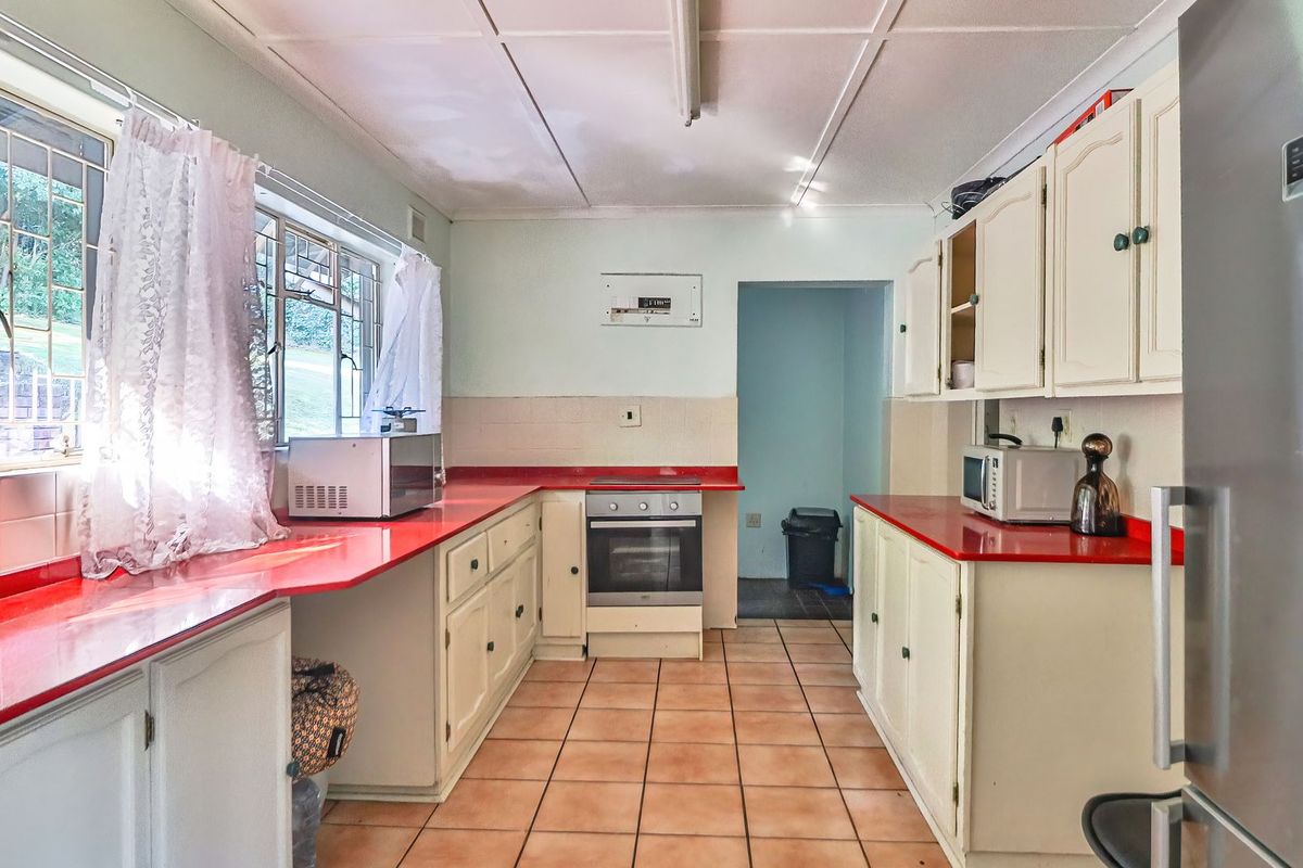 A functional kitchen featuring built-in cabinetry, tiled flooring, and a built-in oven with a tiled backsplash and laminate countertops.