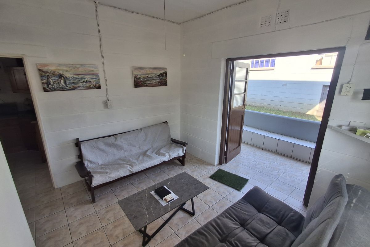 A living room featuring tiled flooring and direct access to an outdoor patio area through a single door.