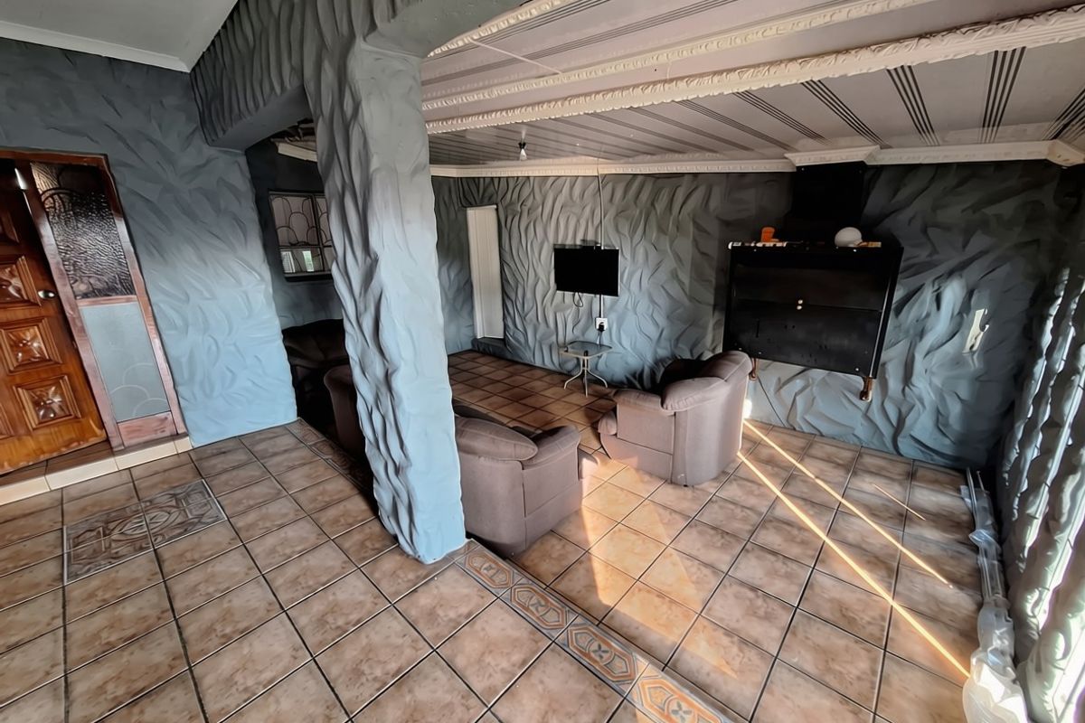 Living room featuring unique textured wall finishes, ceramic tiled flooring, decorative ceiling molding, and a built-in wall-mounted fireplace.