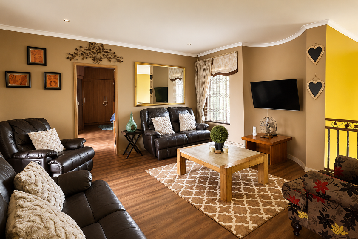 A comfortable living room featuring warm-toned walls, laminate flooring, recessed lighting, and a decorative coved ceiling, providing a cozy and inviting atmosphere.