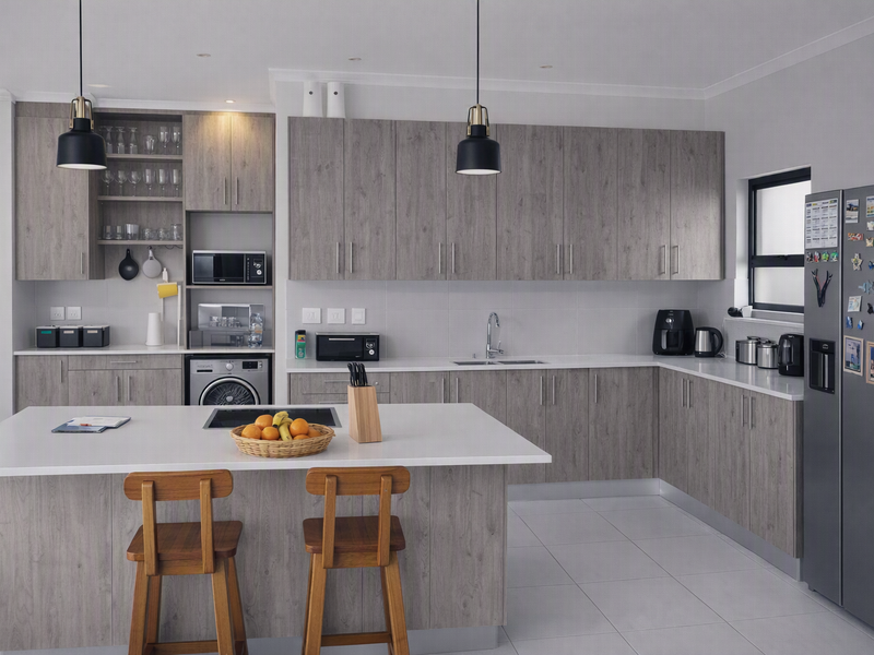 Modern kitchen featuring wood-grain cabinetry, a central island with seating, quartz countertops, integrated appliances, and sleek pendant lighting.