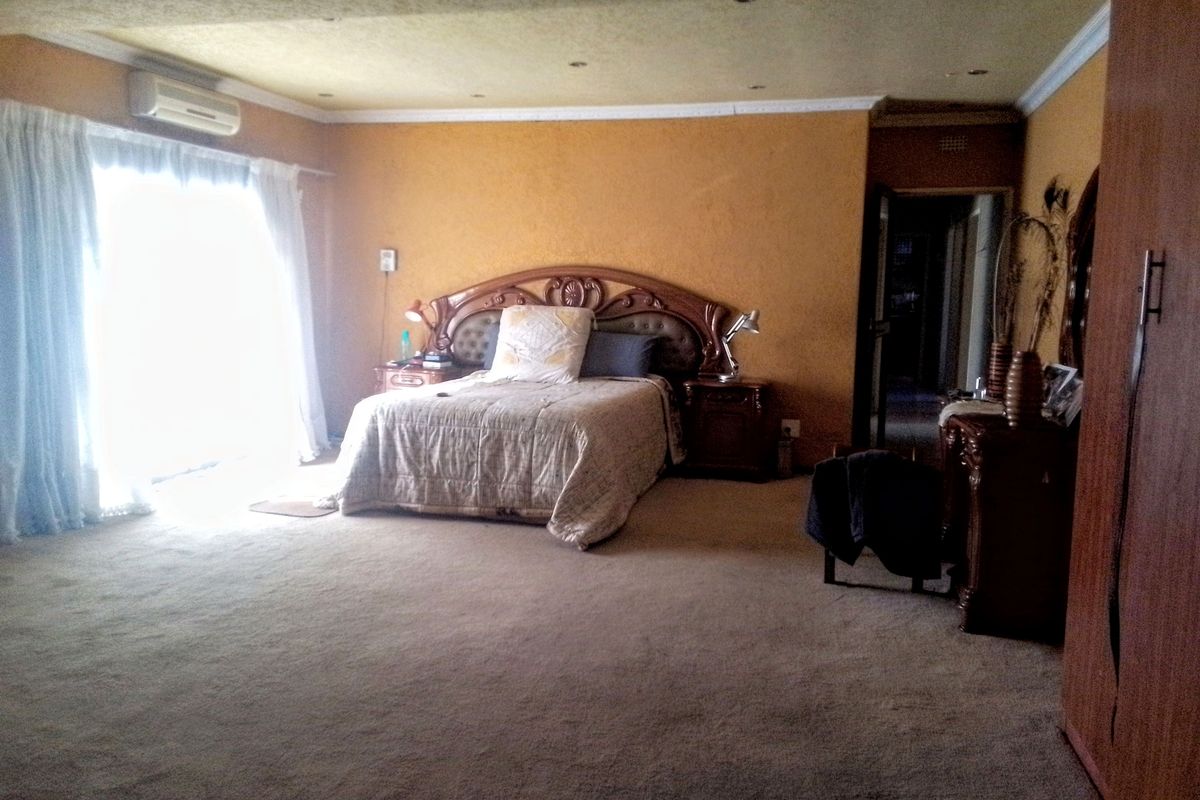 Spacious bedroom featuring wall-mounted air conditioning, sliding door access to the exterior, and built-in wardrobe storage.