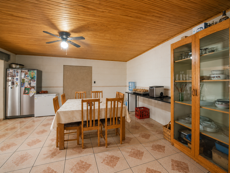 Dining area featuring timber tongue and groove ceiling, tiled flooring, and a built-in wooden display cabinet.
