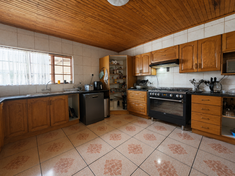 A functional kitchen featuring wooden cabinetry, a gas stove with extractor fan, tiled backsplash, and a convenient corner pantry unit.