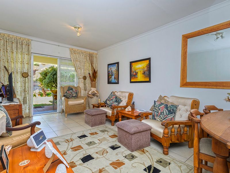 A comfortable living room featuring tiled flooring and a sliding glass door that provides direct access to the outdoor patio area.