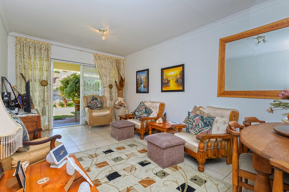 A comfortable living room featuring tiled flooring and a sliding glass door that provides direct access to the outdoor patio area.