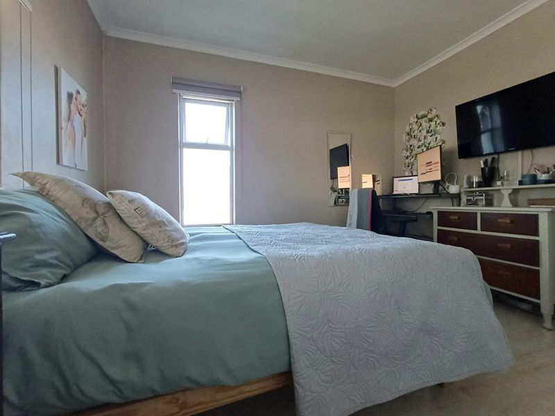A functional bedroom featuring neutral wall tones, coving, and a window, providing a comfortable and versatile living space.