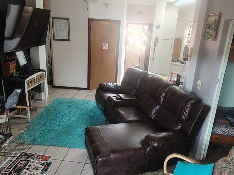 A living room area featuring tiled flooring and access to adjacent rooms, providing a functional layout for the townhouse.