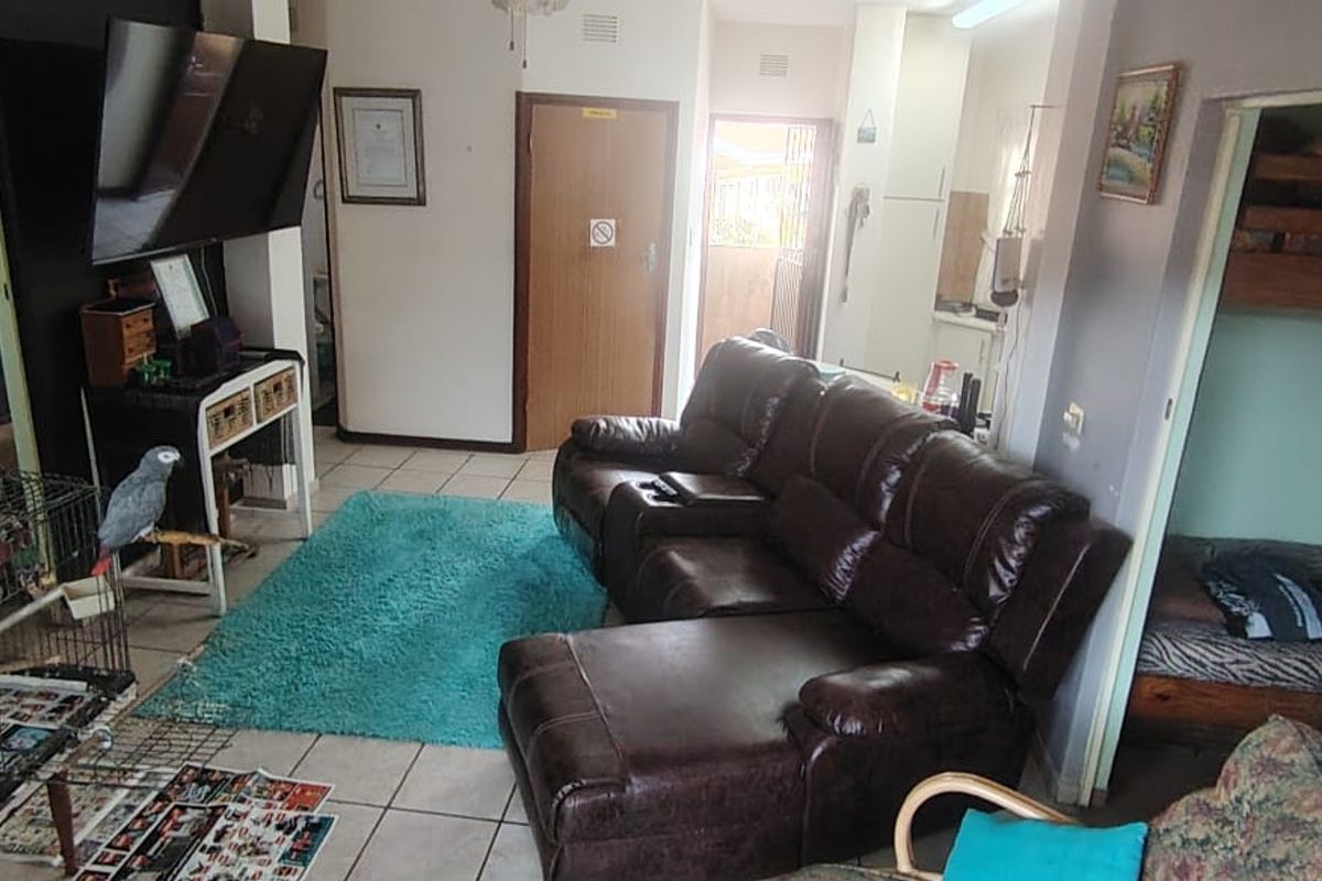 A living room area featuring tiled flooring and access to adjacent rooms, providing a functional layout for the townhouse.