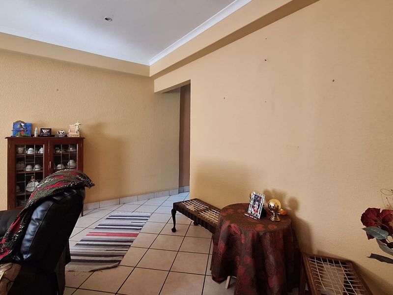 A living area featuring tiled flooring and coved ceilings, providing a neutral foundation for interior design updates.