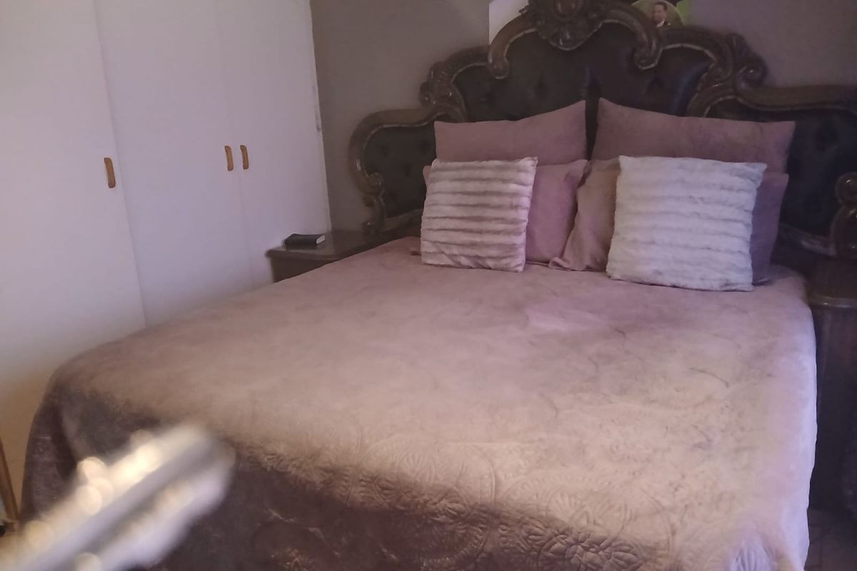 A bedroom featuring built-in cupboards, providing essential storage space within the room.