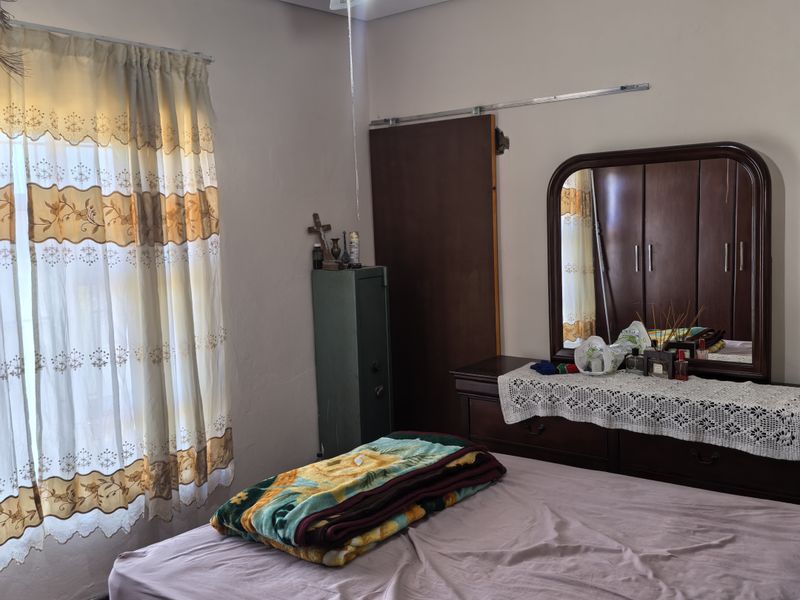 A bedroom featuring a ceiling fan, sliding door access, and carpeted flooring, offering a functional space ready for cosmetic updates.