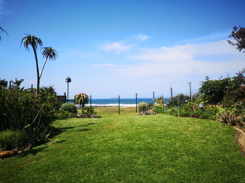 A well-maintained garden area featuring a clear, direct view of the ocean and coastline.