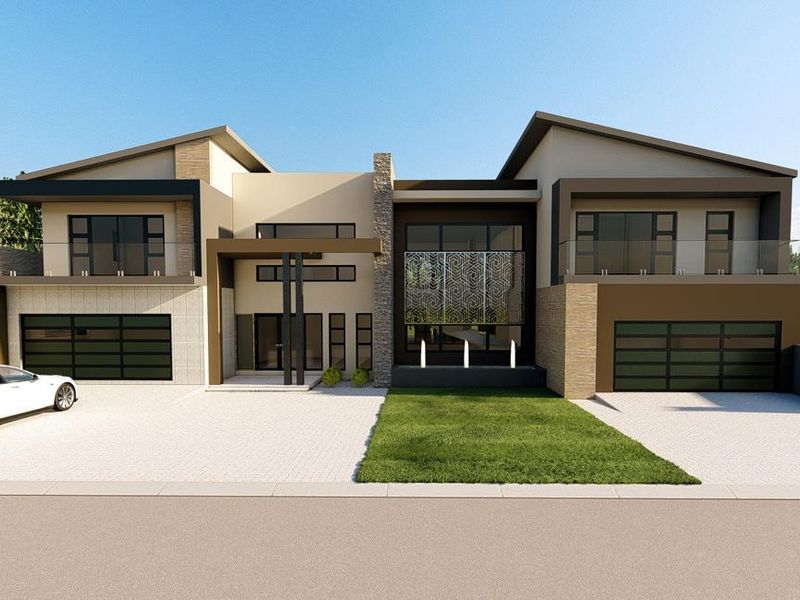 A modern double-story residential facade featuring stone cladding, glass balustrades, and a spacious paved driveway with double garages.
