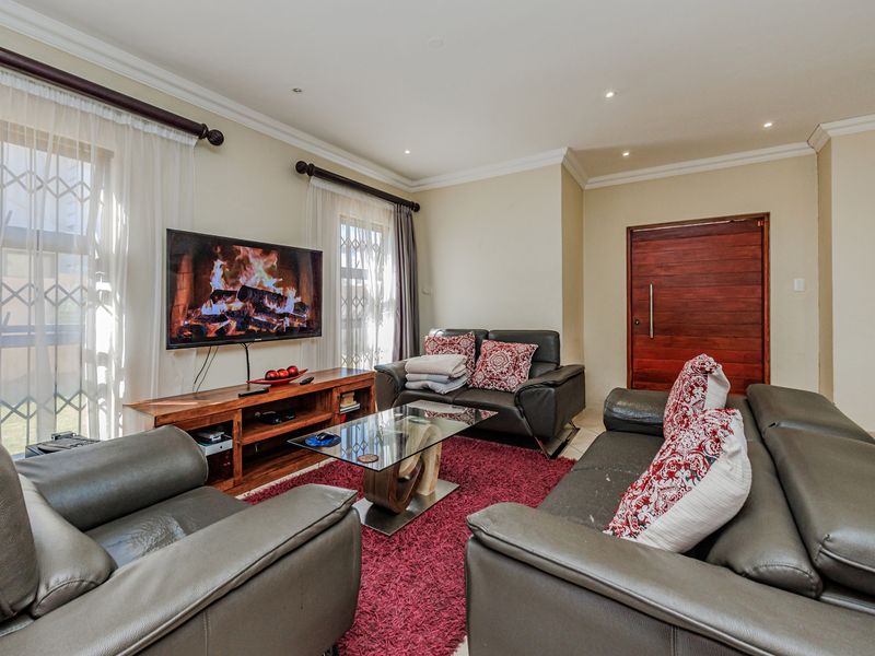 A comfortable living room featuring recessed downlighting, crown molding, and secure window treatments, providing a functional and well-maintained space.