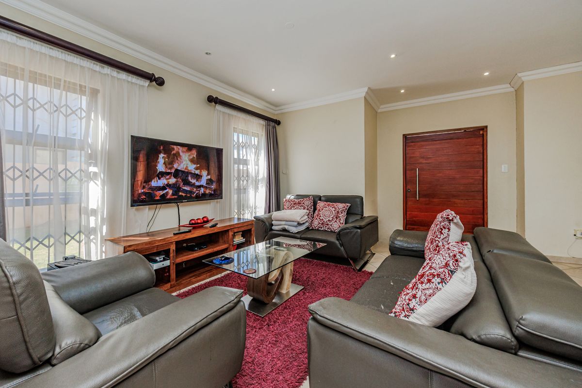 A comfortable living room featuring recessed downlighting, crown molding, and secure window treatments, providing a functional and well-maintained space.