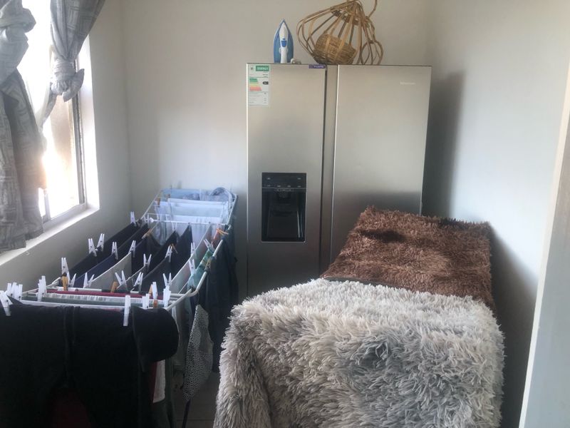 A utility space currently utilized for laundry and storage purposes.