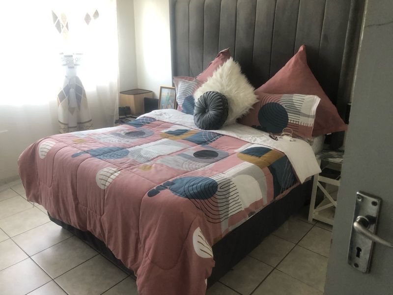 A bedroom featuring tiled flooring and a neutral wall finish, providing a functional space for rest.