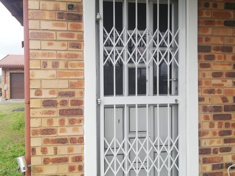 Front entrance featuring a face-brick facade and a white retractable security gate.
