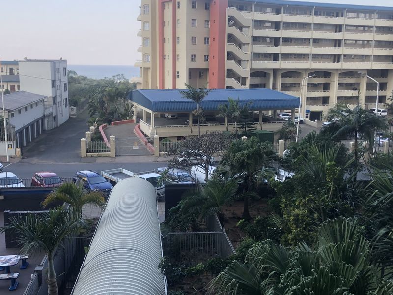 An elevated view overlooking the surrounding neighbourhood, nearby apartment complex, and established garden area.