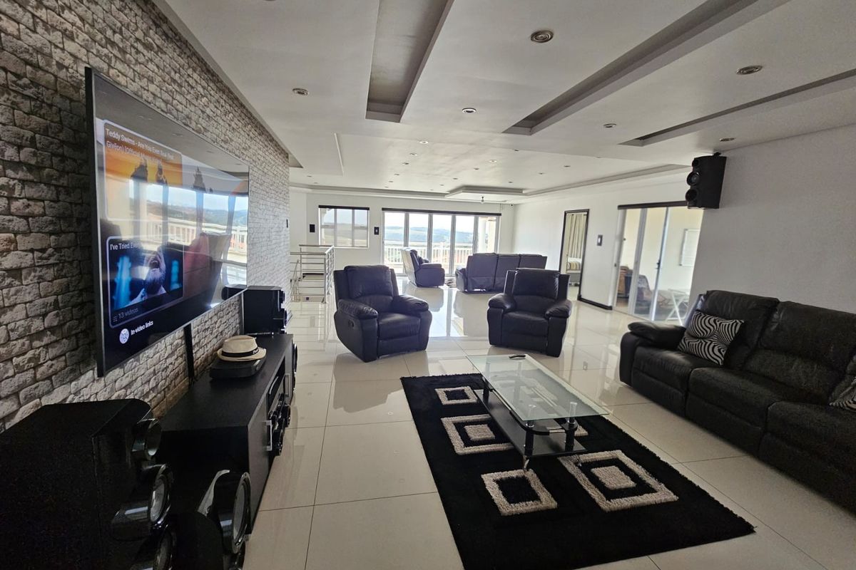 Spacious living room featuring a stone accent wall, recessed ceiling lighting, and large sliding glass doors that provide ample natural light.