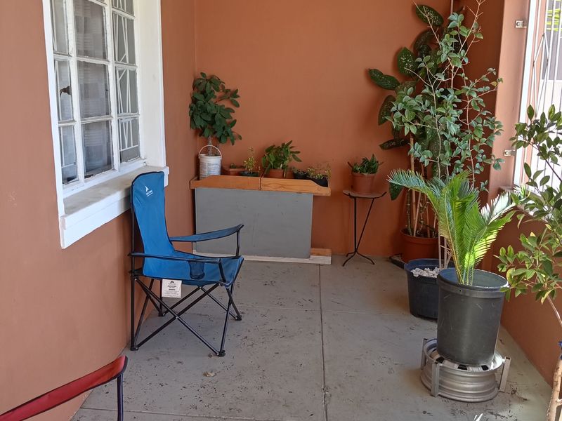 A covered patio area featuring concrete flooring and a multi-pane window, offering a functional outdoor space ready for potential enhancement.