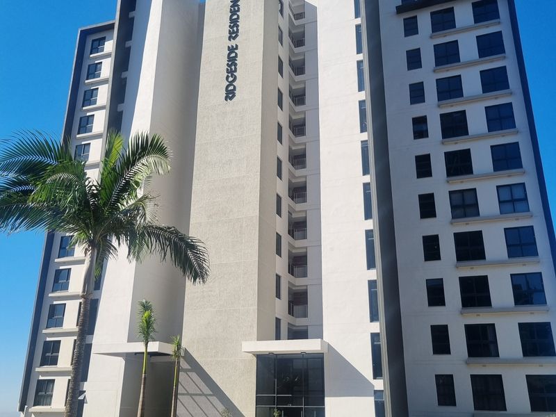 A modern multi-story apartment building facade featuring contemporary architectural design, large glass windows, and well-maintained landscaped grounds.