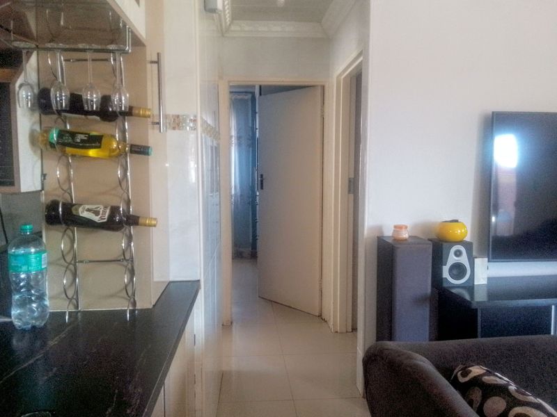 Open plan living area featuring tiled flooring, built-in wine storage, and access to internal rooms through standard doorways.