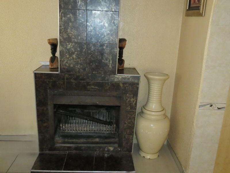 A living room featuring a built-in fireplace with dark decorative tiling and a matching hearth.