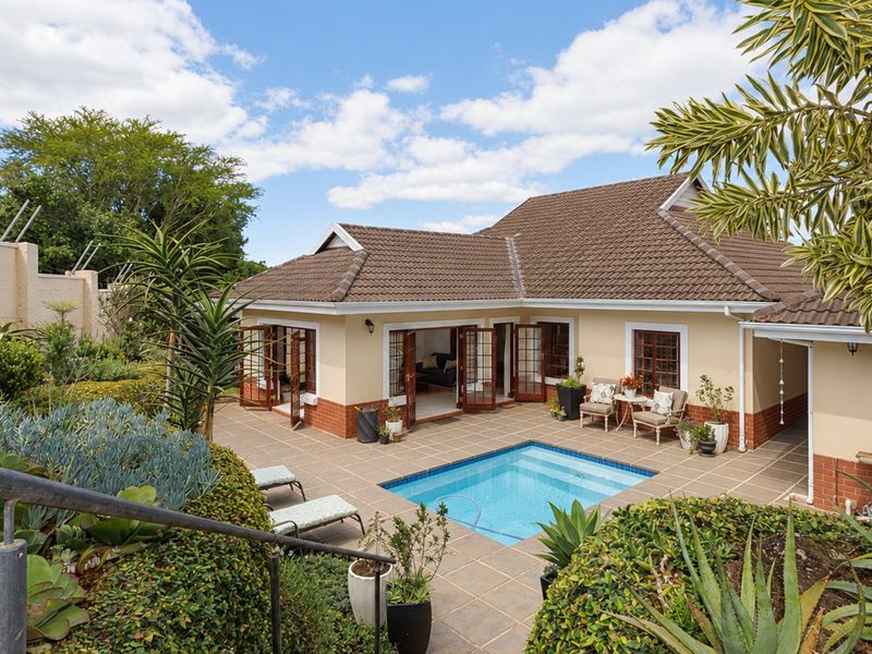 Rear view of the townhouse featuring a private swimming pool, tiled patio area, and direct access through multiple sets of french doors.