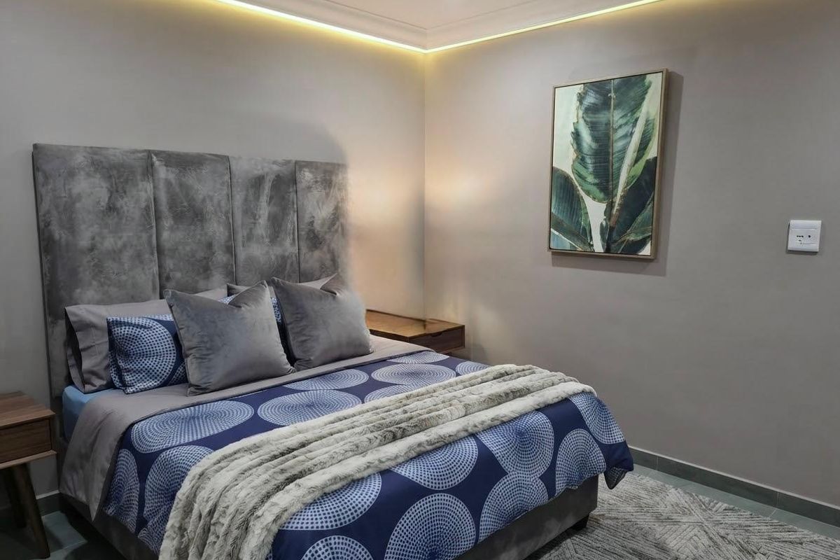 A well-maintained bedroom featuring modern recessed cove lighting and neutral wall finishes, creating a comfortable and contemporary sleeping space.
