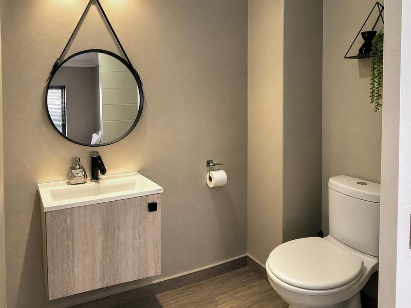 A modern, well-maintained bathroom featuring a wall-mounted vanity with basin, mixer tap, and a standard toilet.