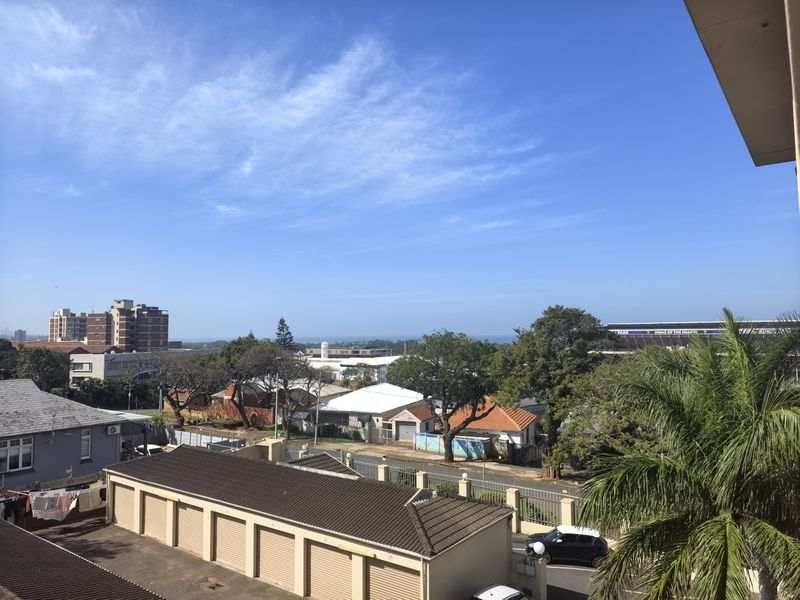 An elevated outdoor view overlooking the surrounding neighborhood, nearby buildings, and distant horizon.