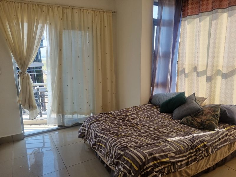 A bedroom featuring tiled flooring and a sliding glass door providing direct access to a private balcony.