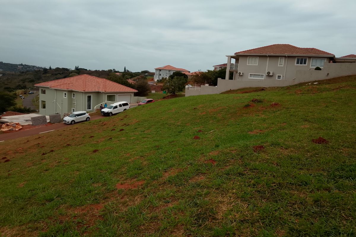 A view of a sloped residential plot overlooking neighboring houses in a suburban estate setting.