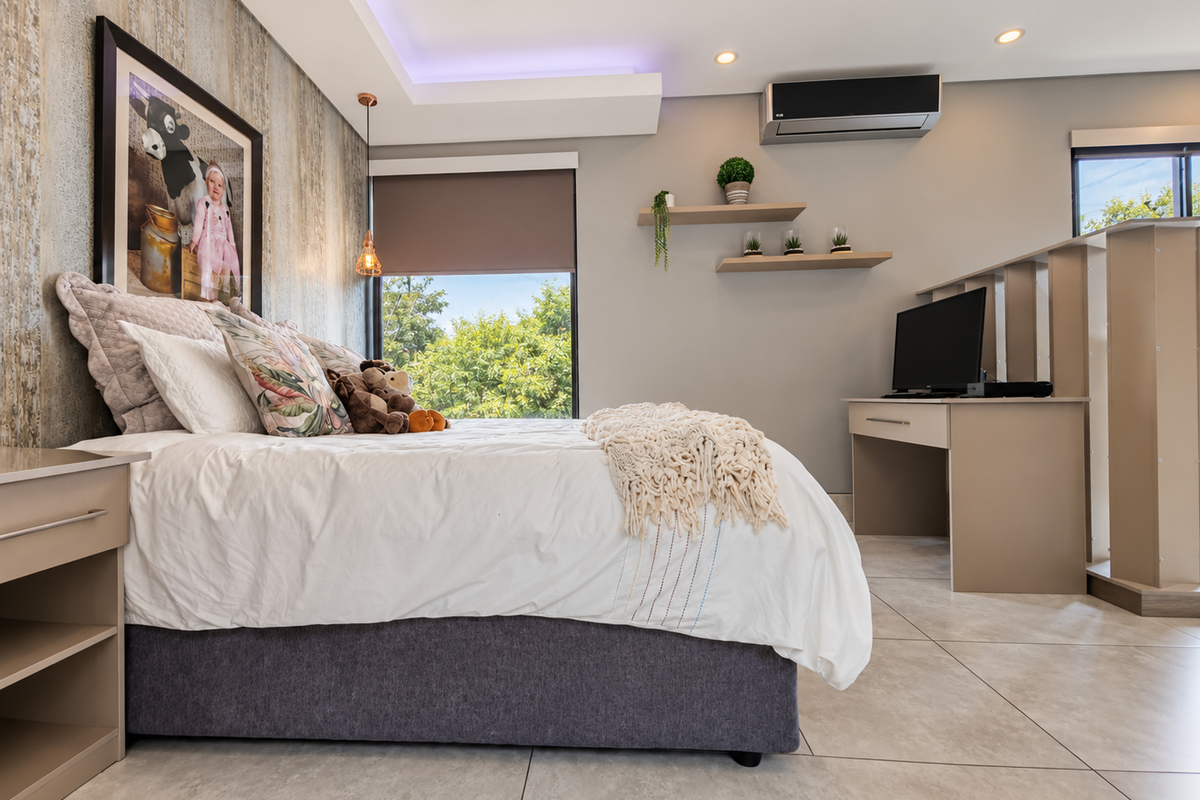 Modern bedroom featuring tiled flooring, a feature wall, recessed ceiling lighting, and a split system air conditioner.
