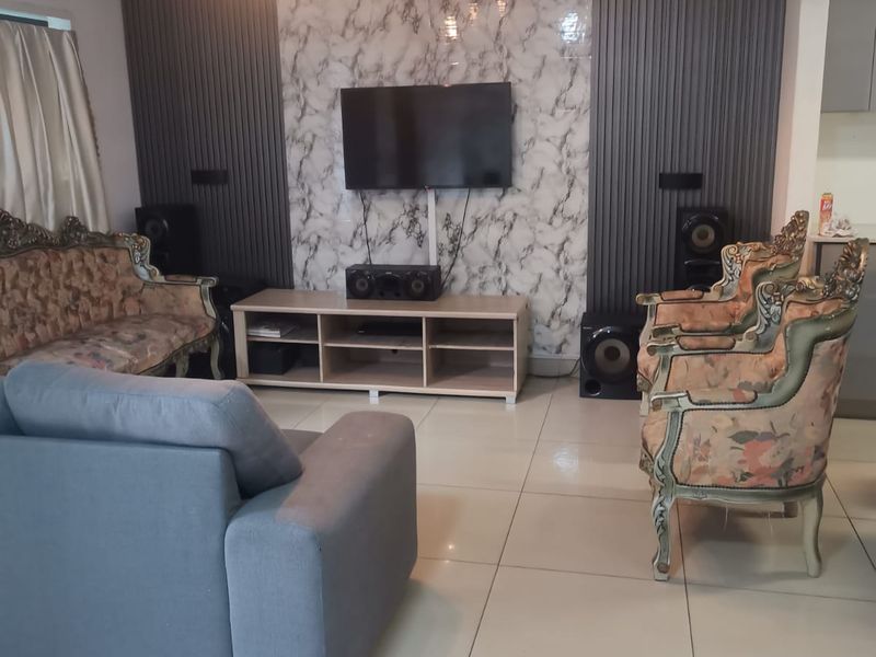 A living room featuring a modern marble-effect feature wall with vertical slat paneling, tiled flooring, and a wall-mounted air conditioning unit.