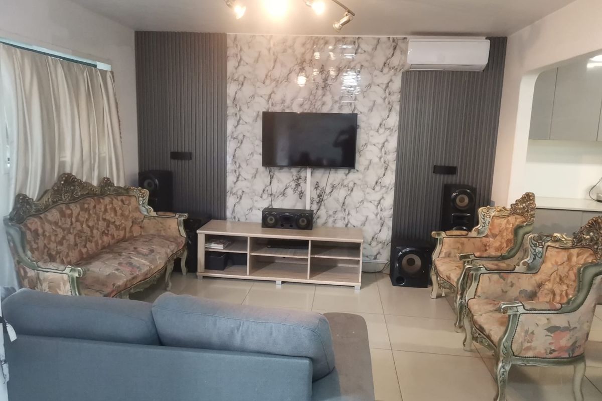 Living room featuring a marble-effect feature wall with vertical slat paneling, tiled flooring, and a wall-mounted air conditioning unit.